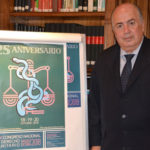 Ricardo-De-Lorenzo,-en-su-despacho,-junto-al-cartel-del-XXV-Congreso-Nacional-de-Derecho-Sanitario.